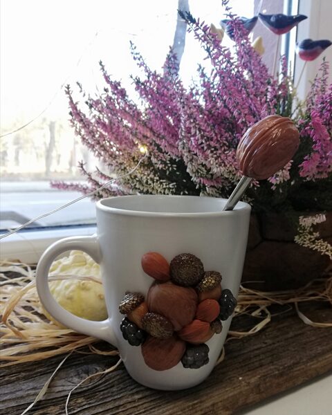 puodelis ir arbatinis šaukštelis su riešutais 